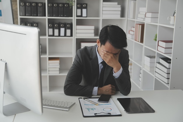 Asian Businesswoman Using laptop computer and working at office with calculator document on desk doing planning analyzing the financial report business plan investment finance analysis concept