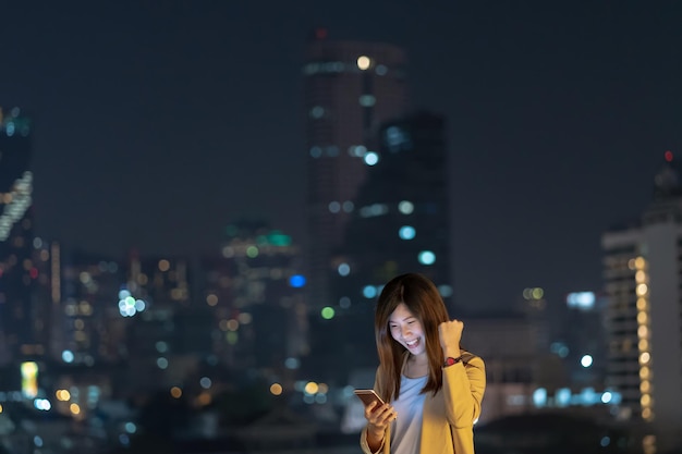 Asian businesswoman using smart mobile phone with smile action