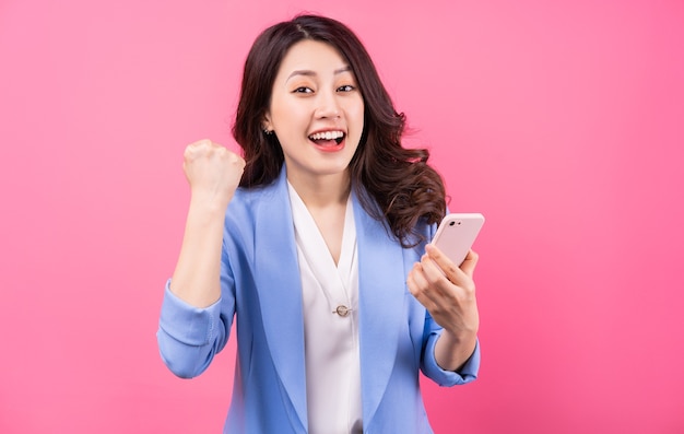 Asian businesswoman using smartphone on pink