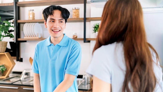 Asian cheerful loving couple close up on a male talking preparing and cooking with joy while standing on a kitchen counter at home Cooking together in their home kitchens