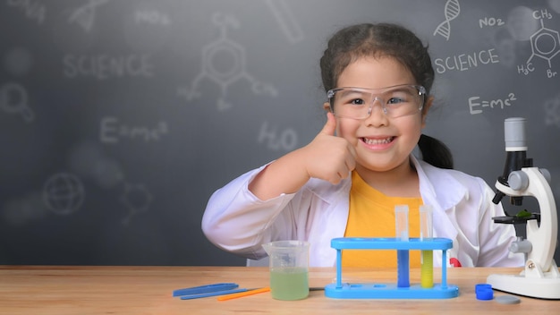 Asian child girl learning science chemistry with test tube making experiment at school laboratory. education, science, chemistry and children concept . Early development of children.