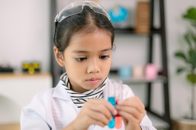 Asian child girl learning science chemistry with test tube making experiment at school laboratory education science chemistry and childrens concepts Early development of children