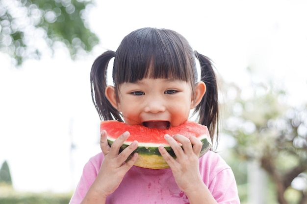 Asian child girl She eating and biting a piece of watermelon