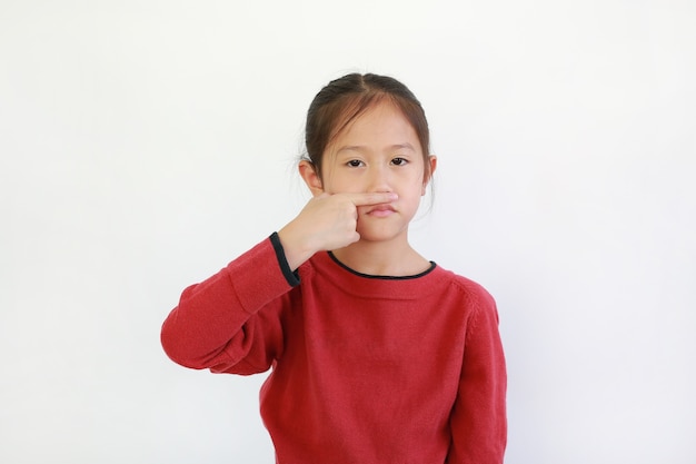 Asian child holding forefinger close his nose while smelling