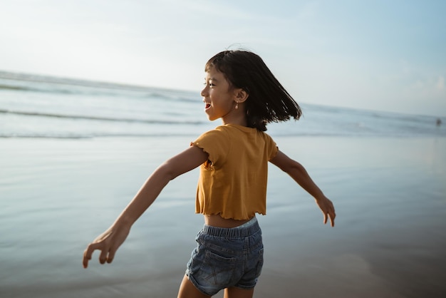 Asian child playing running in the beach enjoy the sunset