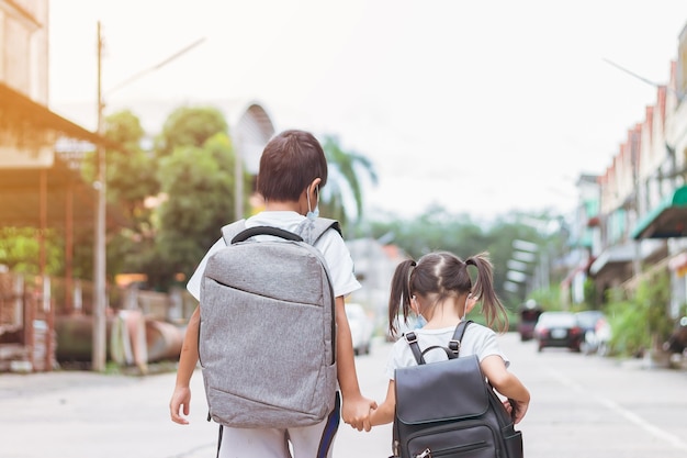 Asian children wearing a face mask and take a school bag Back to school