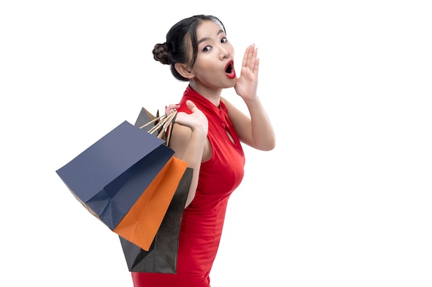 Asian Chinese woman in a cheongsam dress carrying shopping bags