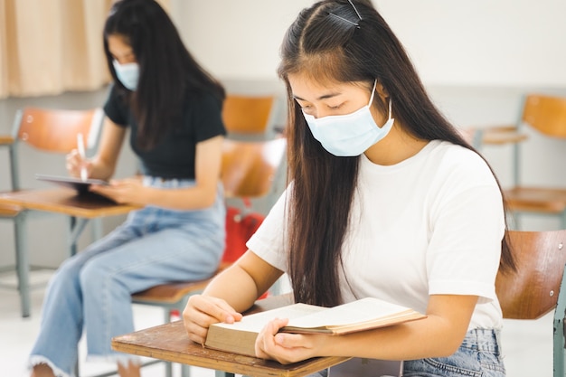 Asian college students back to school with facemask and keep social distance while study in the classroom to prevent COVID-19 pandemic