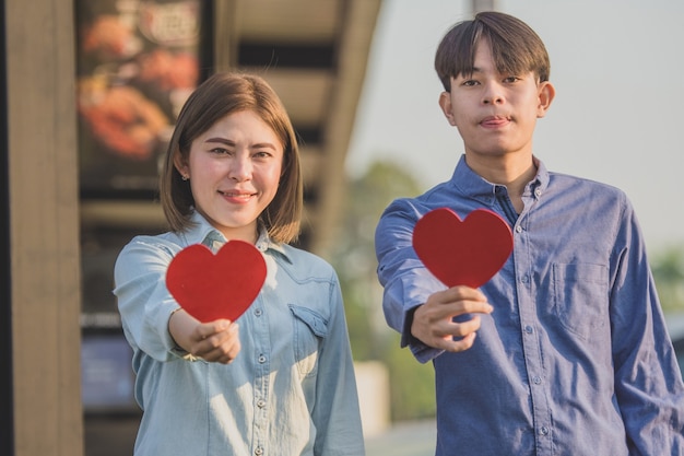 Asian couple holding red heart ,People happy sweet love Valentine, health  insurance , Giving Love together