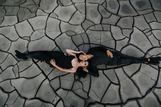 An Asian couple in love hugs while lying on the ground. Back background