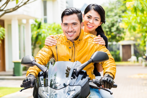 Asian couple riding motorcycle