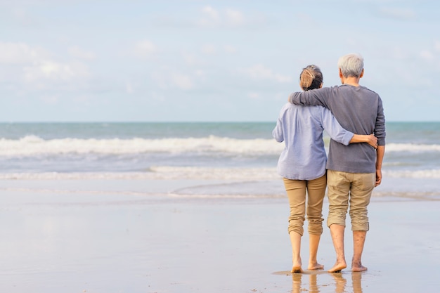 Asian couple senior walking on the beach holding hands.Honeymoon family together happiness lifestyle.Life after retirement.plan life insurance