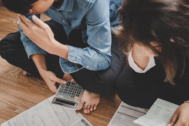 Asian couple sitting stressed and confused by calculate expense from bill have no money to pay