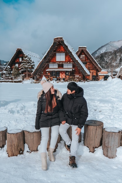 Asian Couple tourist travelling Shirakawago village with white snow Japan Winter Season