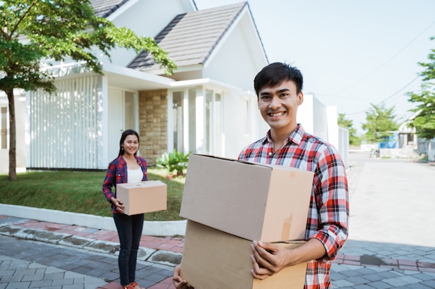 Asian couple with cardboard box in the house