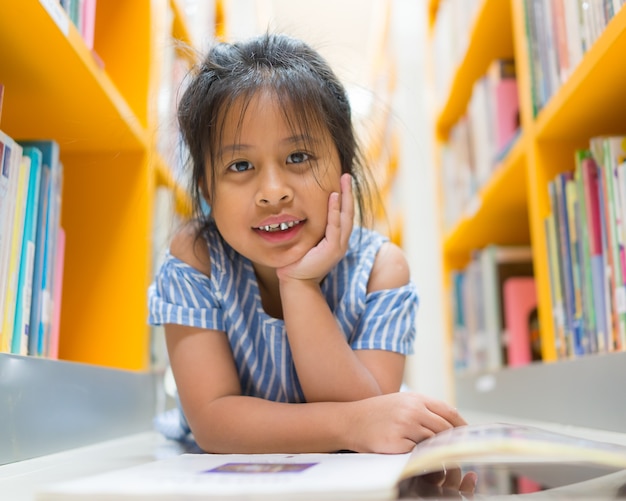 Asian cute girl smiling in the library on blurred book background,