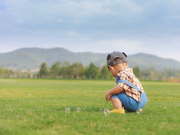 Asian cute toddler boy playing with bubble in nature park