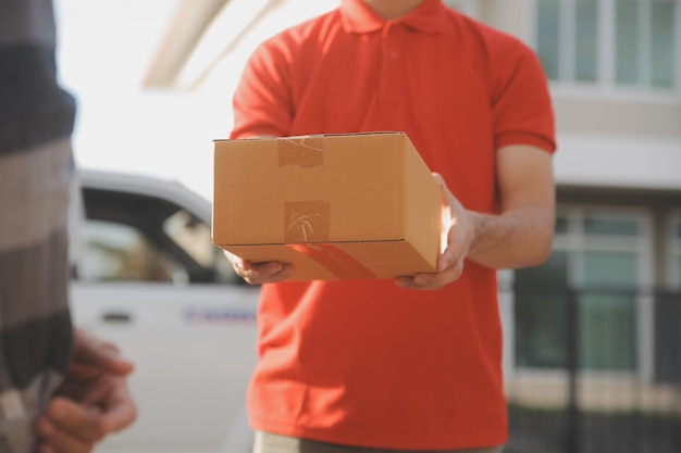 Asian delivery express courier young man use giving boxes to woman customer he wearing protective face mask at front home