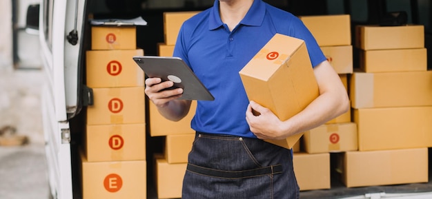 Asian delivery man in cargo van checking boxes