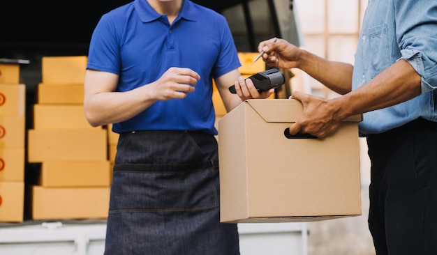 Asian delivery man in cargo van checking boxes