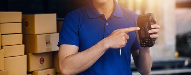 Asian delivery man in cargo van checking boxes