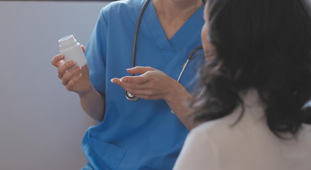 Asian doctor woman visited patient woman to diagnosis and check up health at home or private hospital Female patient explain health problem and symptoms to doctor Health care premium service at home