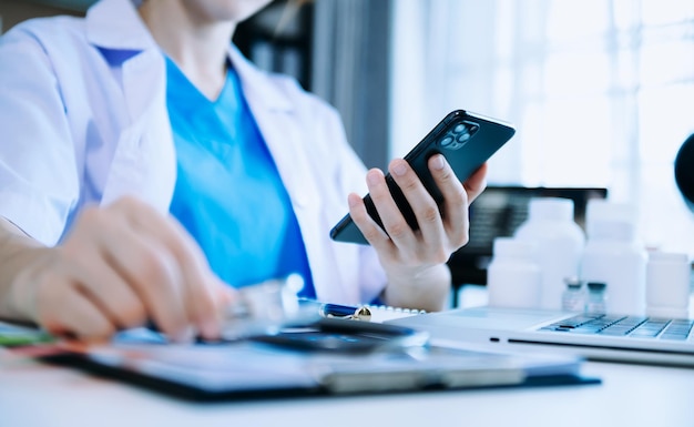 Asian Doctor working with mobile phone and stethoscope in office Medical technology concept