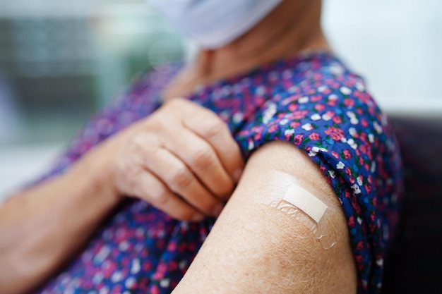 Asian elder senior woman patient getting coronavirus vaccine