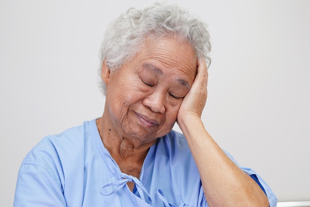 Asian elder senior woman patient suffering from headache with alone in hospital