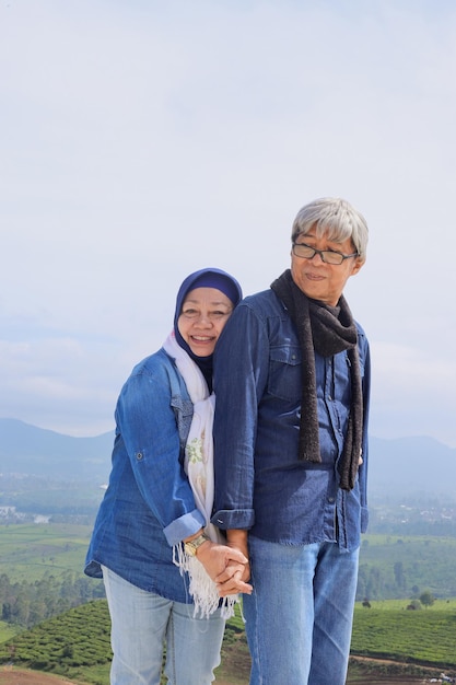 Asian Elderly couple Romantic couple is standing and holding hands each other over landscape view