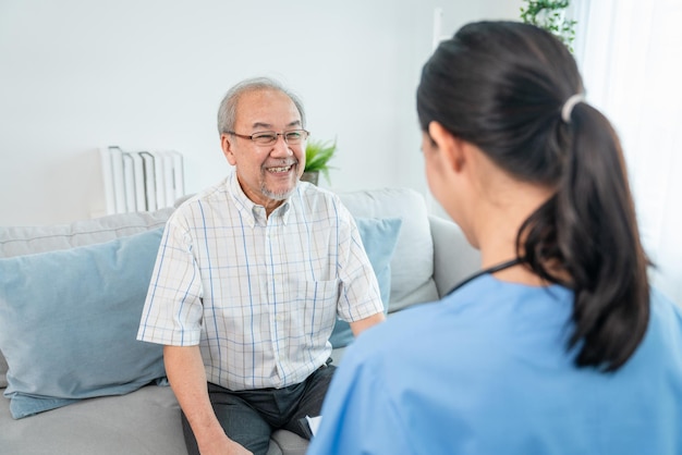 Asian elderly man patient smiling while woman caregiver doctor give consultation about health