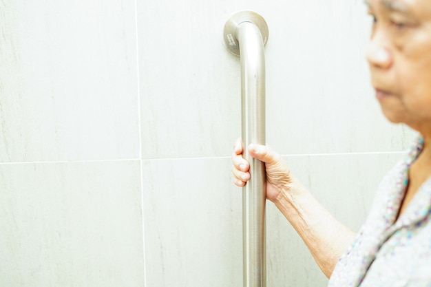 Asian elderly old woman patient use support rail on ramp handrail safety grab bar security in nursing hospital