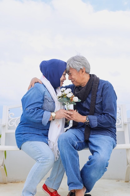 Asian Elderly romantic couple Never ending love couple holds artificial white flower together