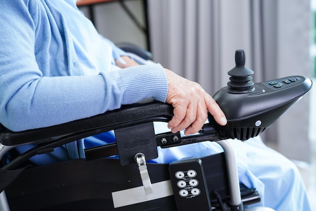 Asian elderly woman disability patient walk with walker in nursing hospital medical concept