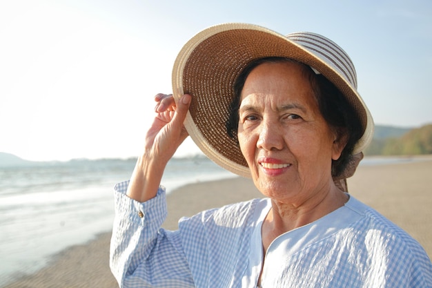 Asian elderly woman Smile happy to come to the sea Retirement tourism Health insurance Elderly society in retirement age