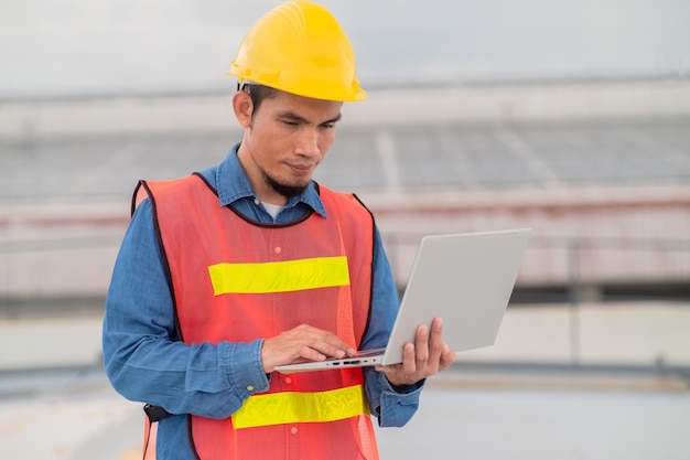 Asian engineer checking on solar power on the roof of factory solar cell green energy