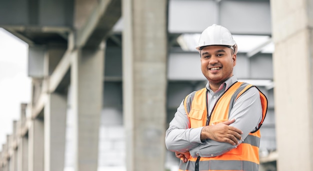 Asian engineer handsome man or architect looking construction with white safety helmet in construction site Standing at highway concrete road site