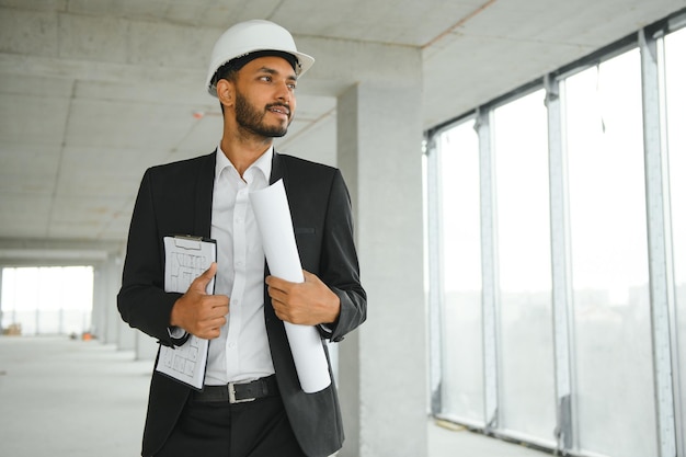 Asian engineer handsome man or architect with white safety helmet in construction site Standing at modern building construction Worker asian man working project building