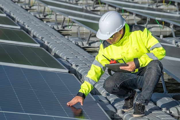 Asian engineer working at Floating solar power plantRenewable energyTechnician and investor solar panels checking the panels at solar energy installation