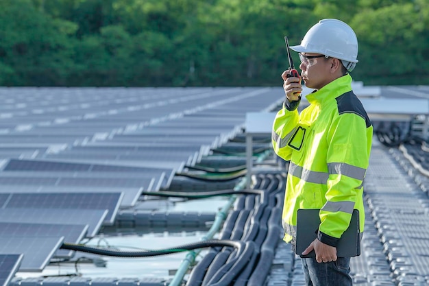 Asian engineer working at Floating solar power plantRenewable energyTechnician and investor solar panels checking the panels at solar energy installation