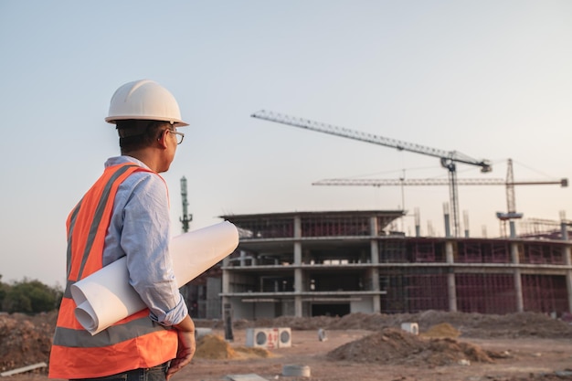 Asian engineer working at site of a large building projectThailand peopleWork overtime at construction site