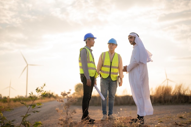 Asian Engineers and Arab businessman checking and inspecting on construction with sunset sky. people