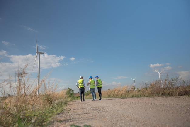 Asian engineers working in fieldwork outdoor Workers walking and inspect construction and machine around project site Wind turbine electrical of clean resource enerdy and environment sustainable