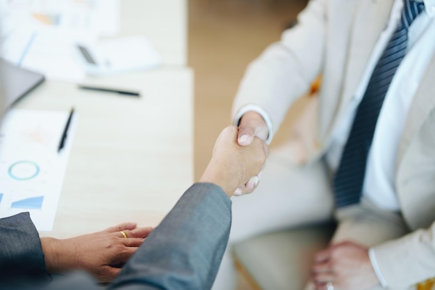 Asian entrepreneurs handshakes to congratulate the agreement between the two companies to enhance investment and financial strength deal concept