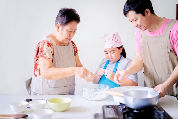 Asian families are helping each other in cooking daughter father and grandmother In their home kitchen