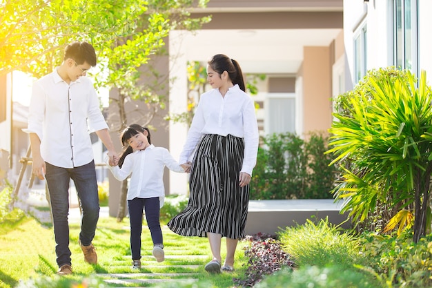 Asian family Parents and children were walking hand in hand together a happy in garden.