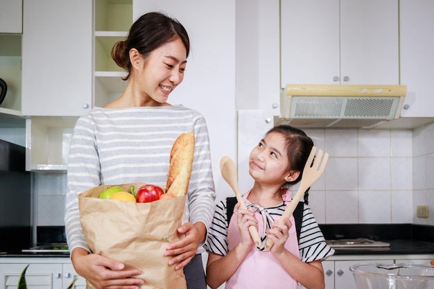 Asian family Portrait of mother and daughter enjoy cooking prepare food together in kitchen at home