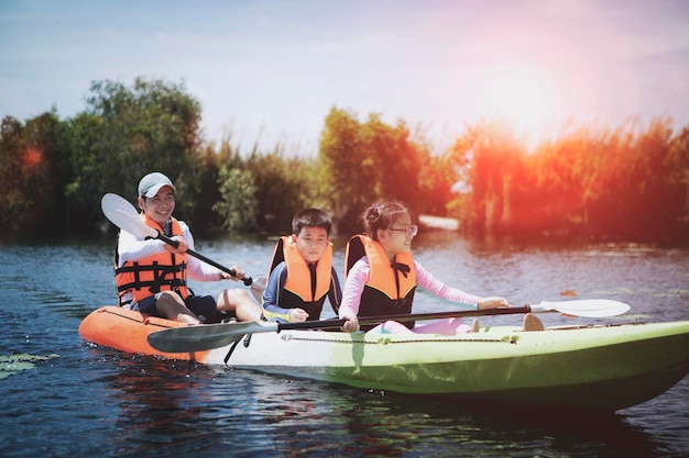 Asian family sailing kayak boat in fresh water lake