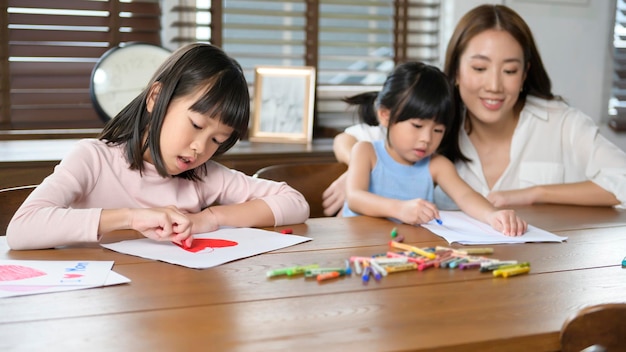 Asian family with children Drawing and painting on table in playing room at home Educational game