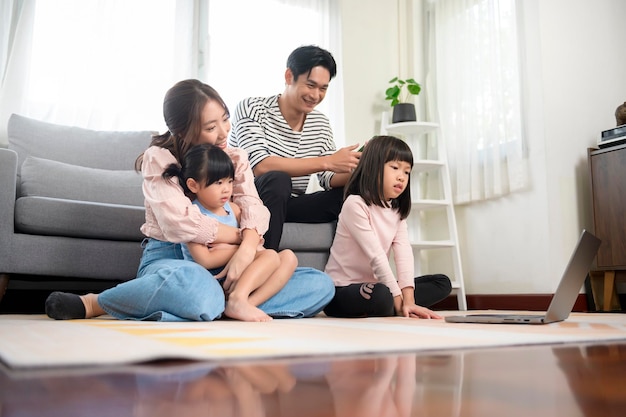 Asian family with children using laptop computer at home